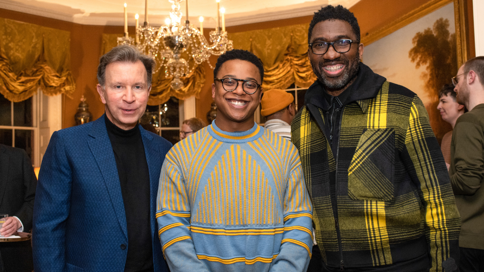 John Studzinski, Taio Lawson and Kwame Kwei-Armah stand in a grand-looking room, dressed in smart attire, smiling at the camera.