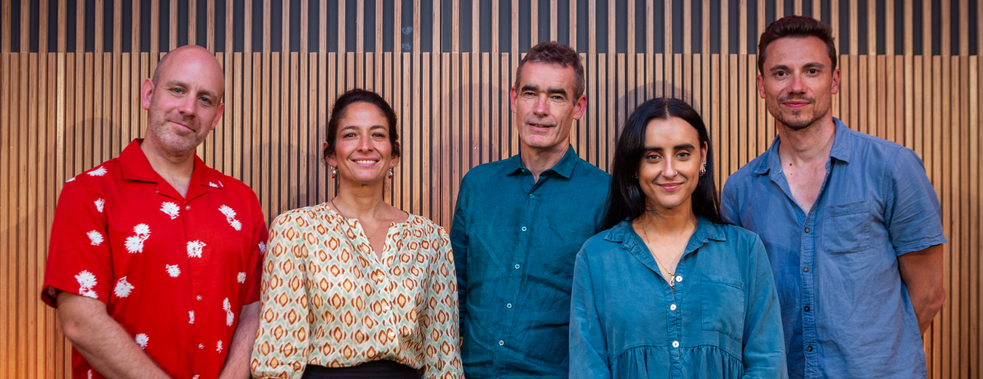 Rob Hastie, Tali Pelman, Rufus Norris, Maimuna Memon and Marc Tritschler stood in a row, smiling at the camera.